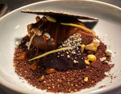 Dessert au chocolat avec tuile croquante, éclats de noisette et poudre de cacao, spécialité culinaire normande du restaurant L'Assiette Normande à Honfleur