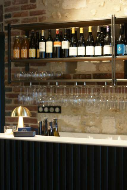 Détail du bar avec étagère en pierre, verres suspendus et lampe dorée, bar honfleur ambiance tamisée, restaurant bistronomique L'Assiette Normande à Honfleur