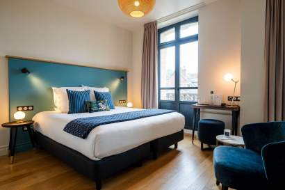 Chambre double avec lit king-size, tête de lit bleue et parquet clair, hôtel Invitation au Voyage Honfleur