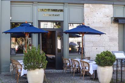 Façade de l'Assiette Normande avec devanture grise, terrasse et parasols bleus, restaurant L'Assiette Normande à honfleur centre ville