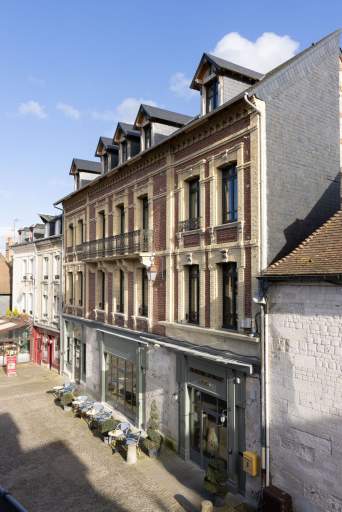 Façade de bâtiment haussmannien en pierre claire dans une rue de Honfleur, restaurant L'Assiette Normande à Honfleur centre ville