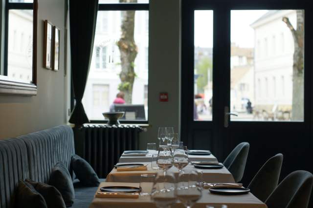 Table dressée en salle lumineuse avec verres, couverts et vue sur rue, où manger à Honfleur centre ville, restaurant L'Assiette Normande