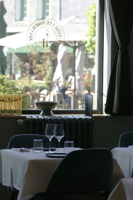 Table près d'une fenêtre donnant sur jardin, dressée avec verres et couverts, salle du restaurant L'Assiette Normande à Honfleur
