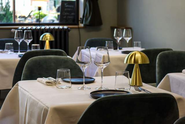 Table avec lampes champignon dorées, verres à pied et couverts sur nappe blanche, restaurant L'Assiette Normande à Honfleur centre ville