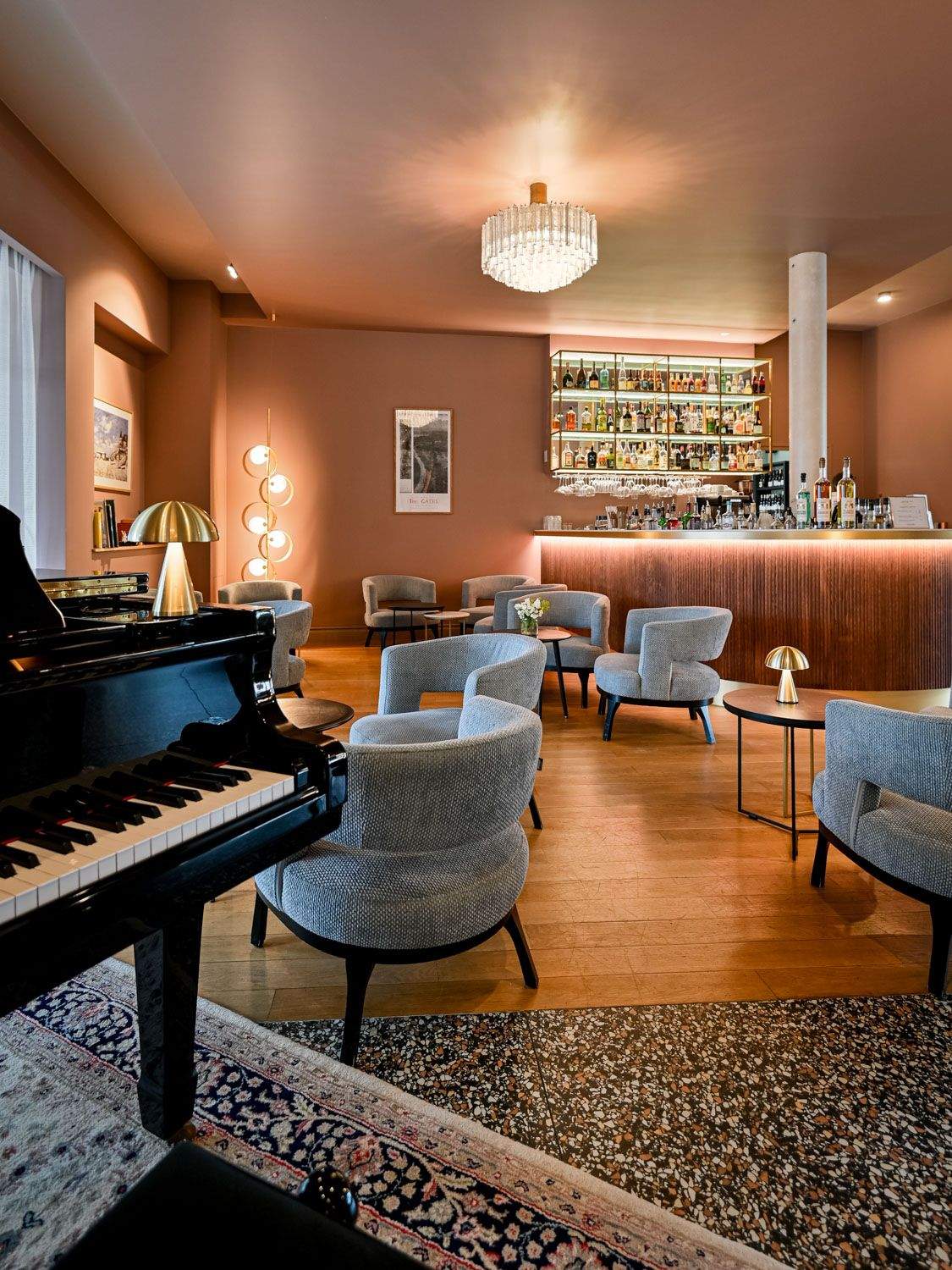 Comptoir de bar avec étagères dorées garnies de spiritueux et fauteuil en velours, bar honfleur centre ville
