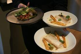 Serveur présentant des assiettes de poisson blanc avec légumes et bouillon, restaurant L'Assiette Normande à Honfleur au centre ville
