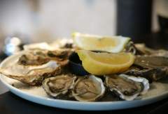 Assiette d'huîtres fraîches ouvertes avec quartiers de citron, fruits de mer Honfleur servis en entrée de L'Assiette Normande